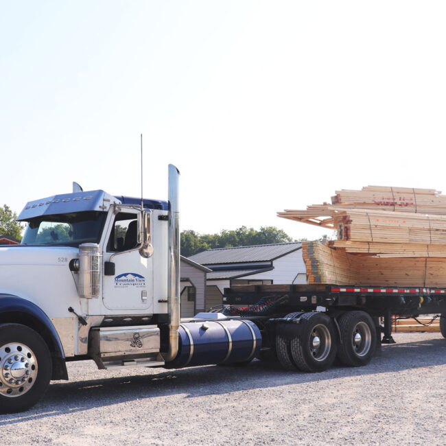 Mountain view transportation semi hauling large wooden trusses