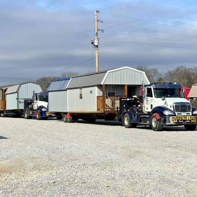 Two Semi truck delivering multiple sheds